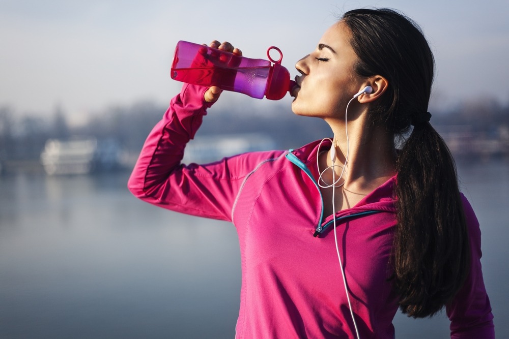London jogger drinking from refillable sports bottle 