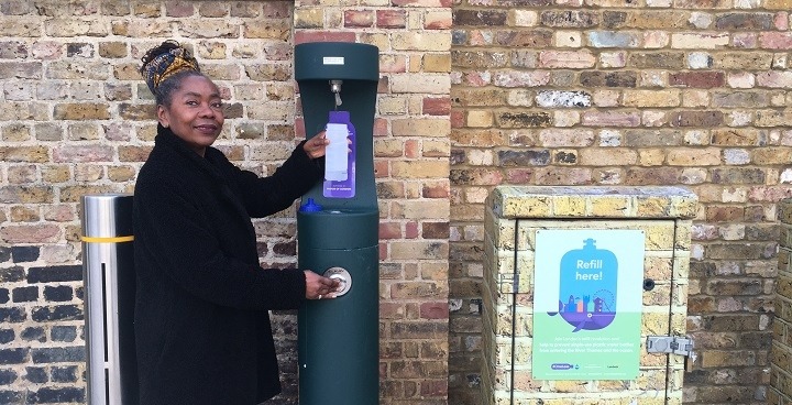 Woman refilling her bottle at an outdoor refill station in Windrush Square.