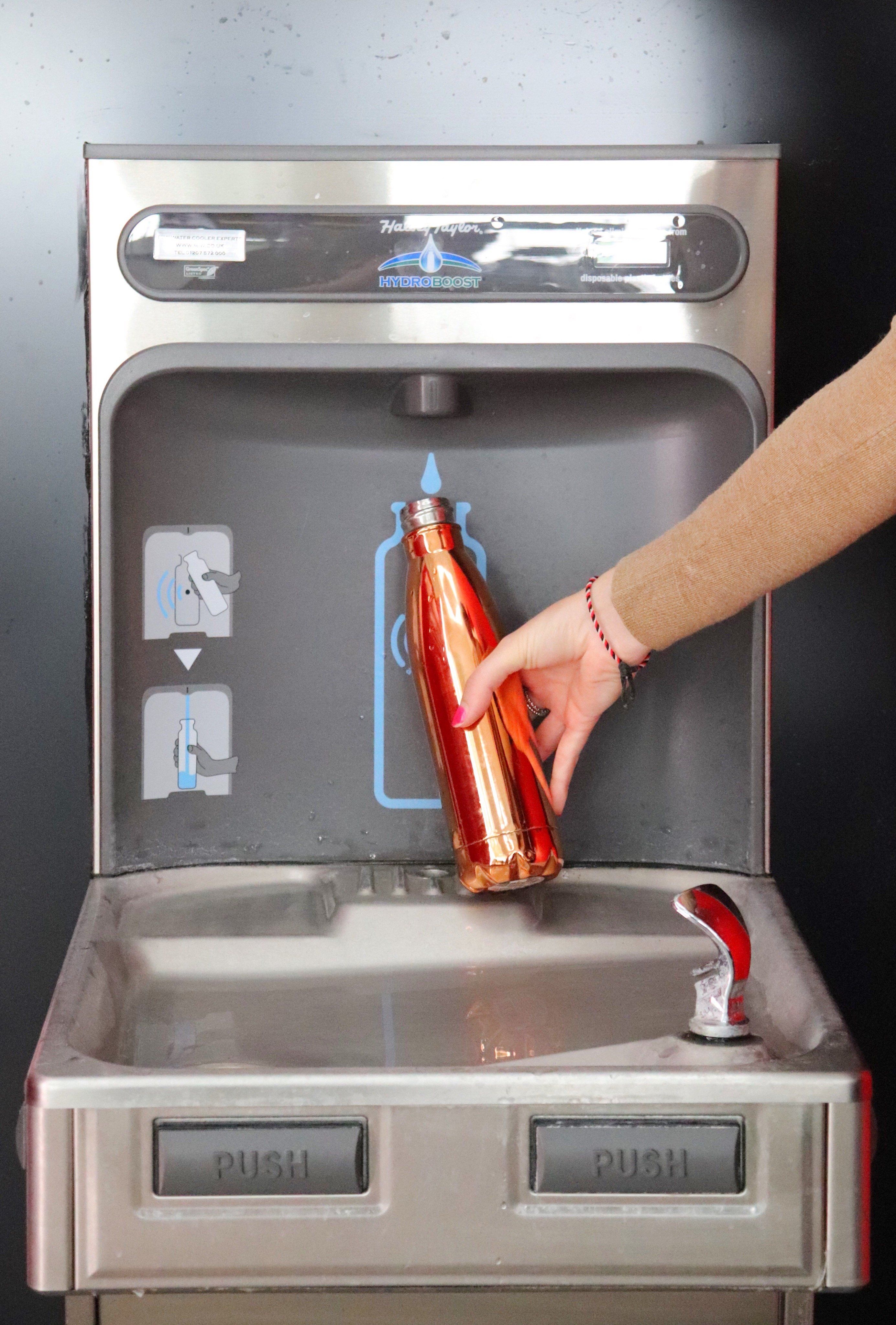 Customer refilling their reusable water bottle at the new bottle filler.