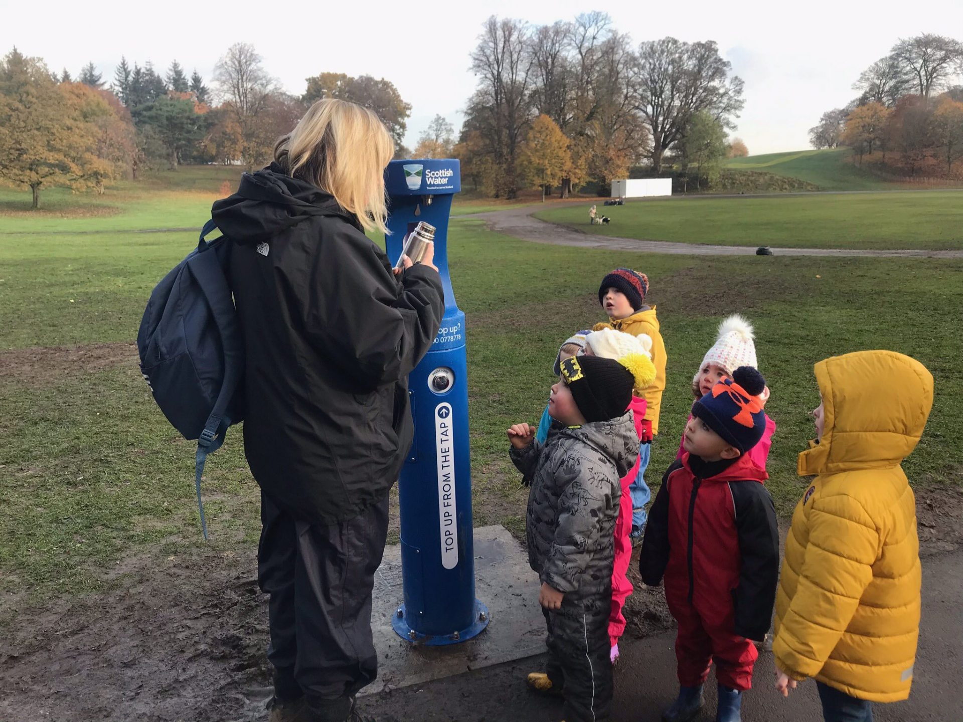 Teacher and children refilling their water bottles at the new bottle filler.