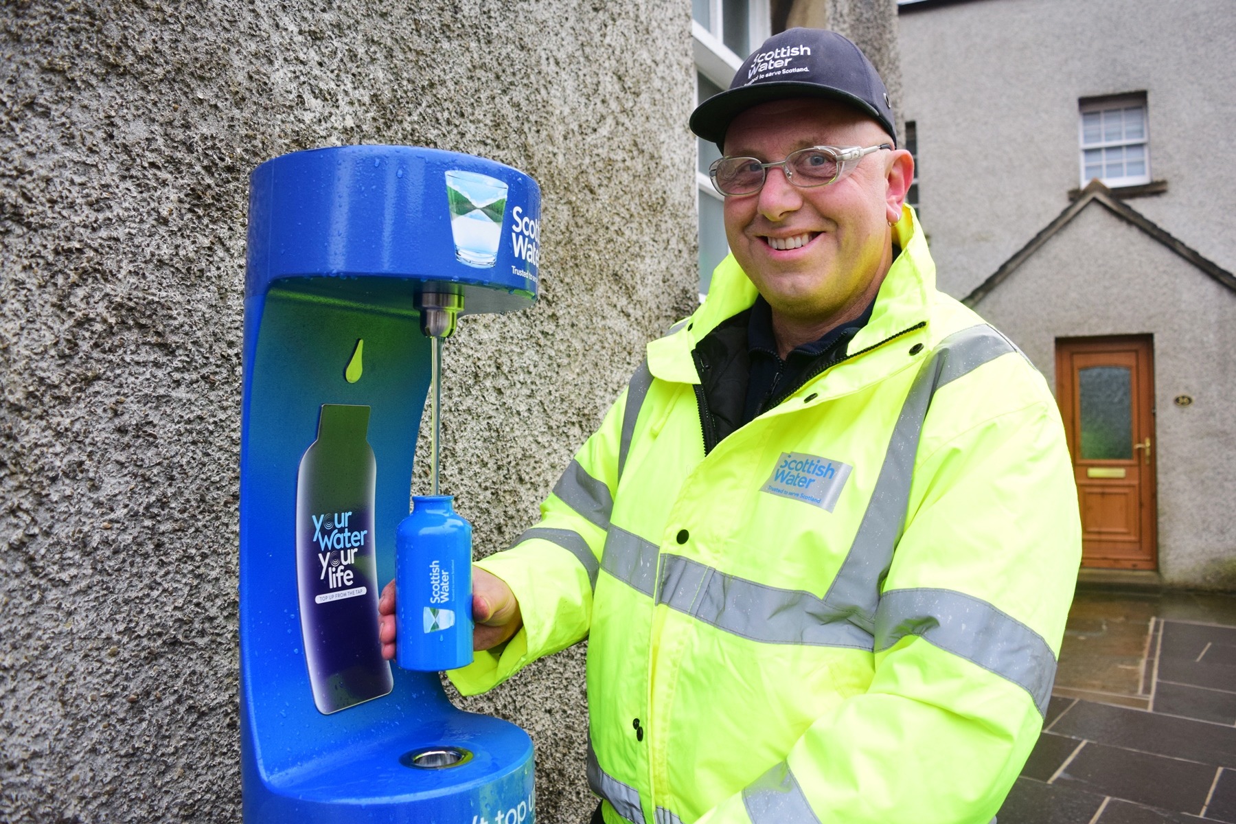 Man refilling his reusable bottle from the new water dispenser in Kirkwall