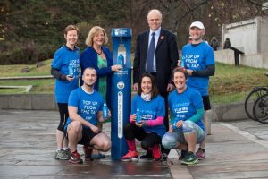 Image of people standing next to blue water fountain 